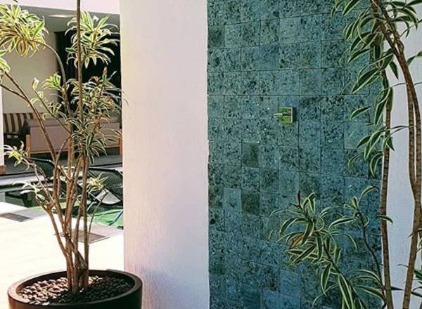 chuveiro externo com parede revestida de pedra hijau bruta artemano revestimentos naturais