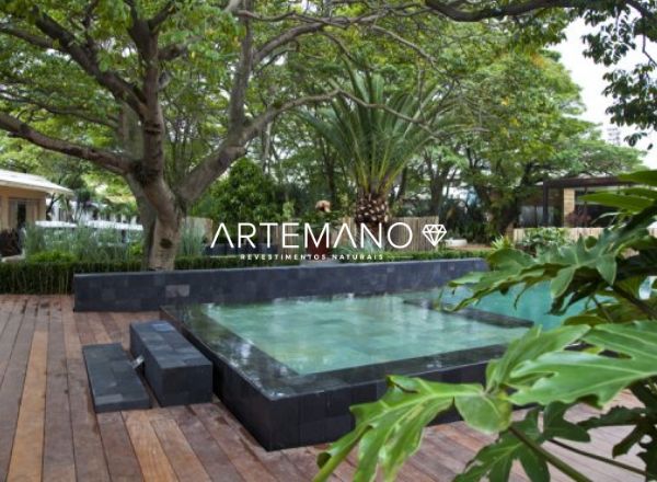 projeto de area externa com aplicacao de pedra hitam revestindo as bordas da piscina