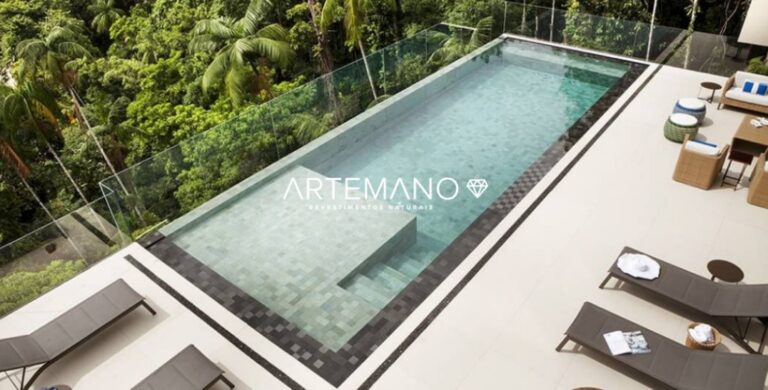 Piscina grande na encosta de um morro. Abaixo há arvores.