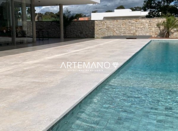o marmore travertino e um piso atermico sendo ideal para revestir a borda da piscina como no projeto da imagem