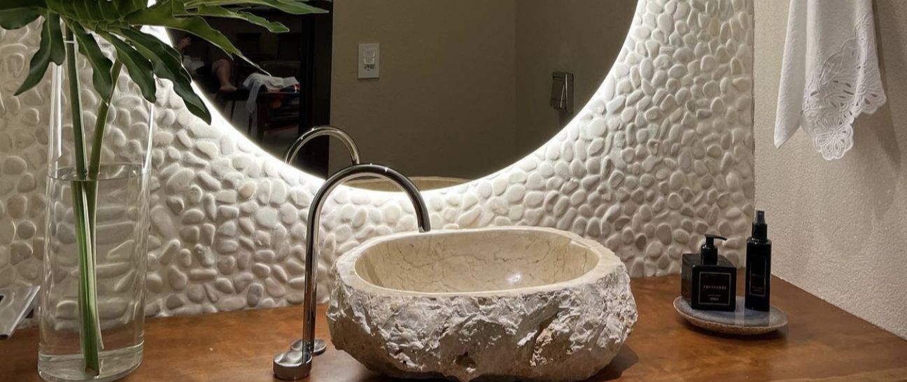 lavabo sofisticado revestido por seixo telado artemano e cuba de pedra natural