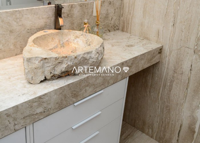 Banheiro com revestimentos, bancada e cuba de mármore travertino Artemano Revestimentos Naturais.