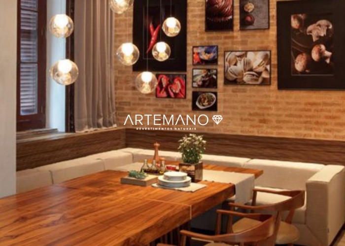 Sala de jantar aconchegante com parede revestida por tijolo inglês Artemano.