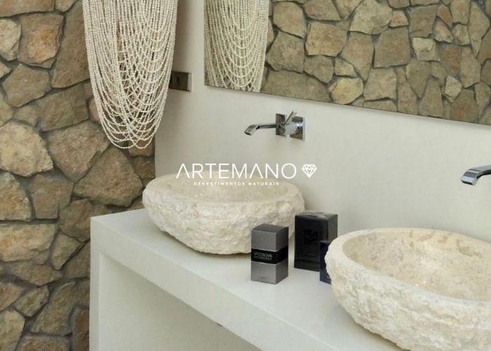 Feita de mármore, esta cuba esculpida para banheiro combinou perfeitamente com as paredes revestidas por pedra natural.