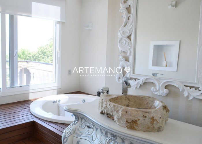 Lindo projeto de banheiro requintado predominantemente branco, combinando com a cuba de mármore travertino.