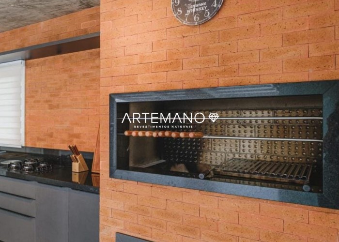 Área gourmet moderna com churrasqueira e rodabanca revestidos por tijolo Namíbia Artemano.