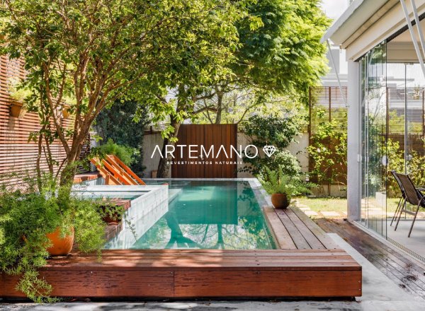 Projeto de piscina combinando madeira com revestimentos naturais Artemano.
