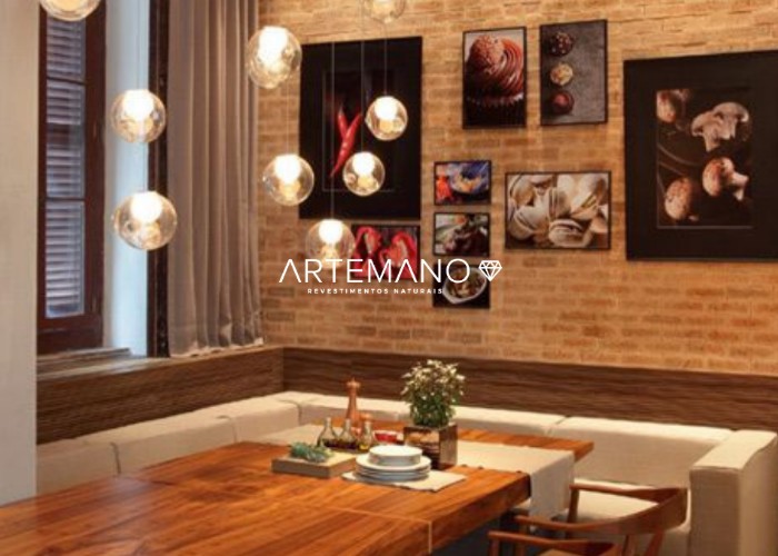 Sala de jantar aconchegante com parede revestida por tijolo inglês Artemano